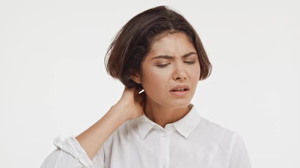 Thoughtful Young Beautiful Brunette East Asian Female in Shirt Standing in Hesitation on White