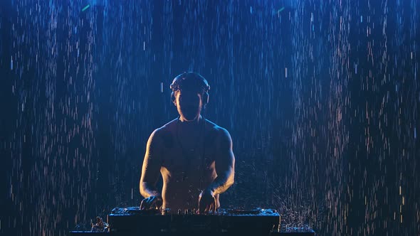 Sexy Male Dj in Professional Headphones Plays on the Control Panel for Mixing Music in a Dark Studio