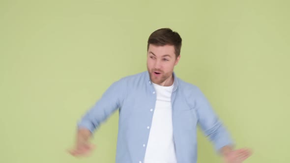 Happy American Man in Denim Shirt Funny Dancing Isolated on Yellow and Green Background in Studio