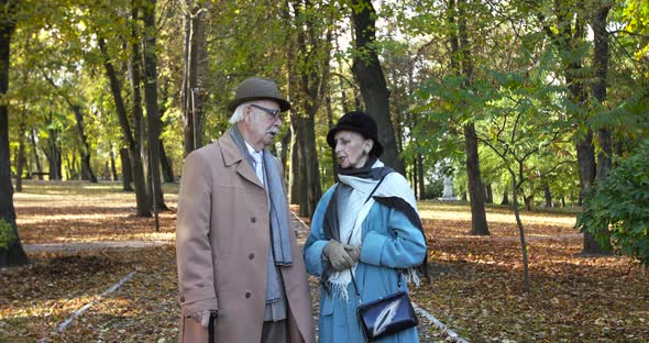 Elegant Retired Family Couple Talking During a Walk in the Autumn Park