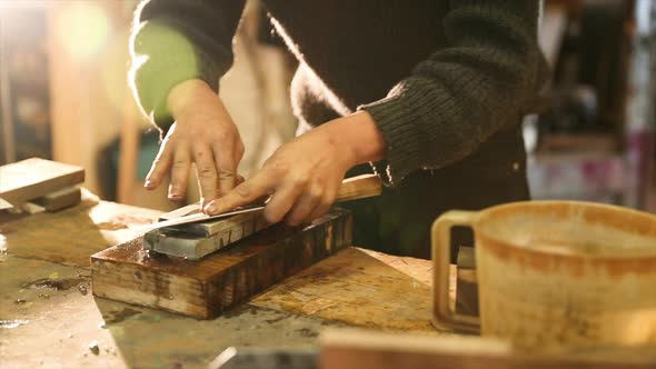Bladesmith grinding a knife on grindstone