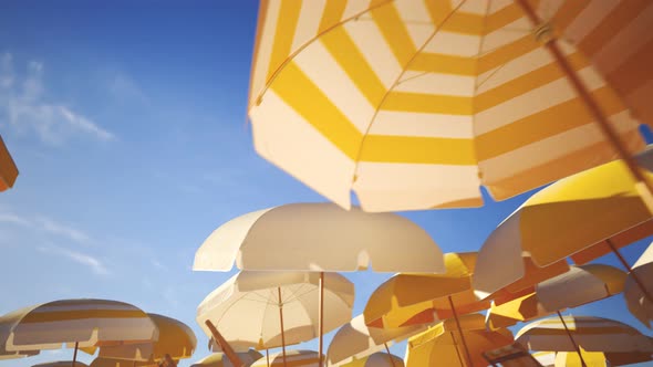 Vacations and travel concept. Yellow umbrellas or parasols against blue sky.