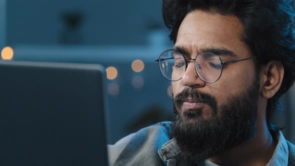 Thoughtful Arabian Indian Bearded Adult Man Thinking of Problem Solution Working on Laptop at Home