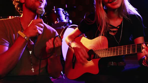 Couple playing guitar and singing song at nightclub