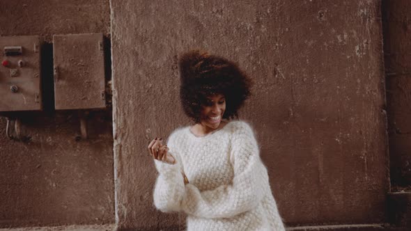 Smiling Woman With Windswept Afro In Woollen Dress And High Heeled Boots