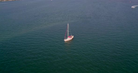 Flying Towards a Sail Boat on Calm Ocean Water