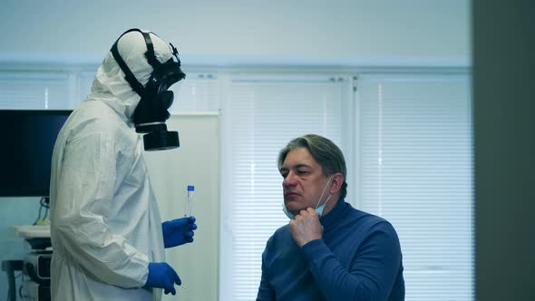 Paramedic in a Splash Suit Is Taking Patient's Saliva for a Test. Screening Patient Covid-19