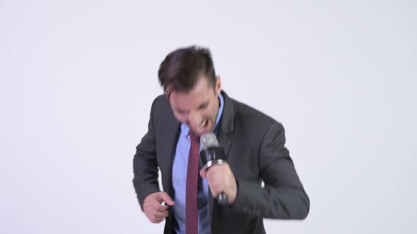 Young Handsome Hispanic Businessman Singing with Microphone