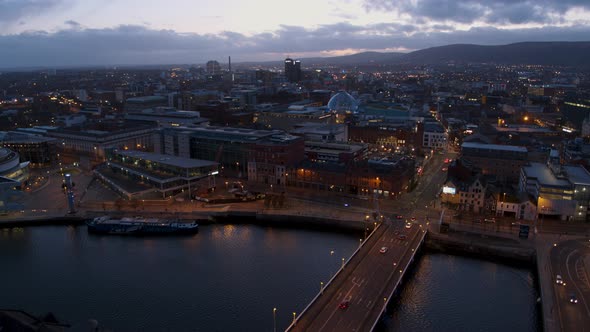 Aerial flyover of Belfast City Centre and Lagan River at night