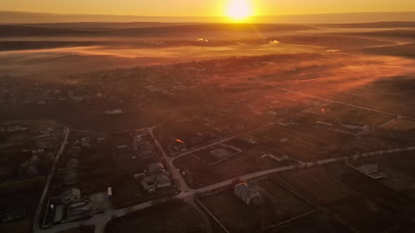 Aerial drone view of the nature of Moldova in autumn. Village, yellowed vegetation, sunset, fog in t