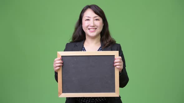 Mature Beautiful Asian Businesswoman Showing Blackboard