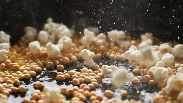 Popcorn popping on heated fry pan. Slow Motion.