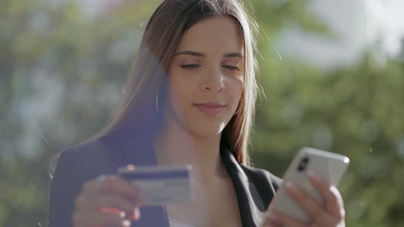 Smiling Young Woman with Smartphone and Credit Card