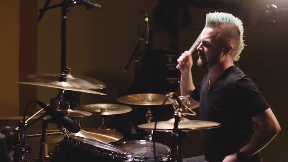 Hard rock drummer performing in a studio setting.