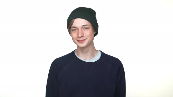 Portrait of Positive Hipster Teenager Wearing Hat Smiling Showing Thumb Up Being in Good Mood Over