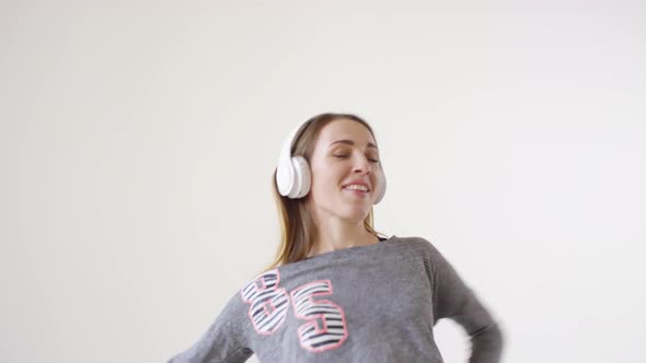 Young Joyous Woman in Headphones Dancing in Studio