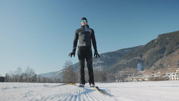 Man In Skiwear Dropping His Skis To The Snow And Walking Forward