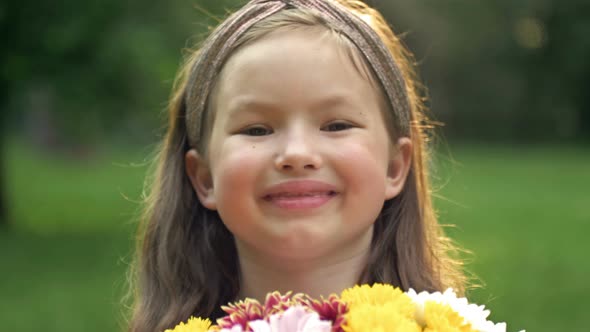 Summer Portrait of a Cheerful Toothless Girl 67 Years Old with a Bouquet of Flowers