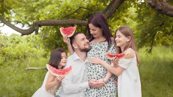 Positive Caucasian Family in Summer Clothes Posing Together at Green Garden and