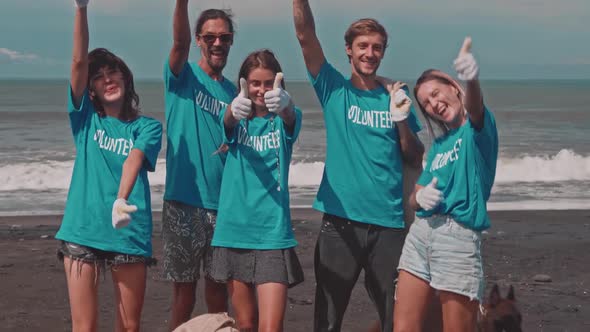 Volunteers Showing Thumbs Up on the Ocean Beach Celebrating Victory