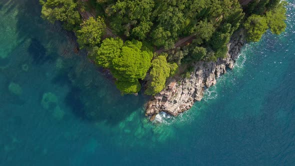 Triangular Shape Rock with Trees and Walkway and Turquoise Sea Water Surrounding It