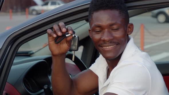 beautiful African American man in a car with keys