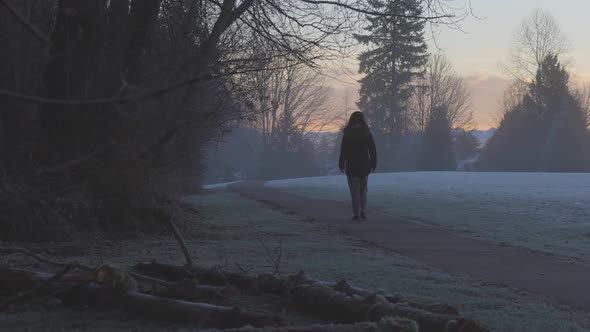 Girl Walking in a Park During Foggy Winter Sunrise