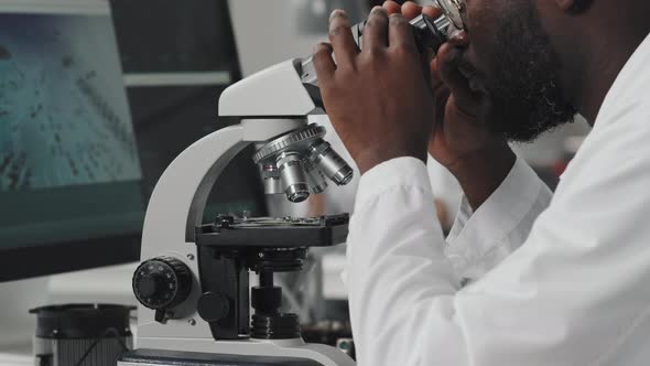 African American Engineer Working with Microscope in Lab