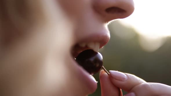 Closeup Portrait of Beautiful Woman's Face Eating a Cherry
