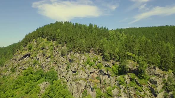 Aerial: Take Off Over the Stone Mountain with Coniferous Forest