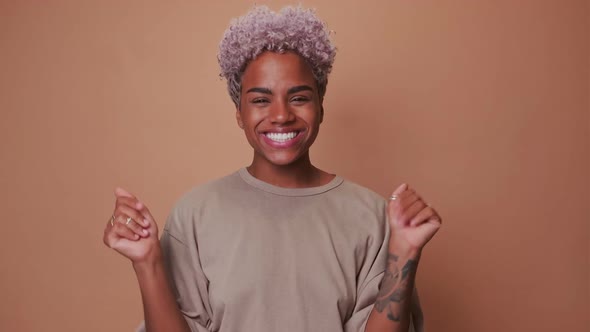 Young Curly African American Woman Shouting with Joy and Waving Hands