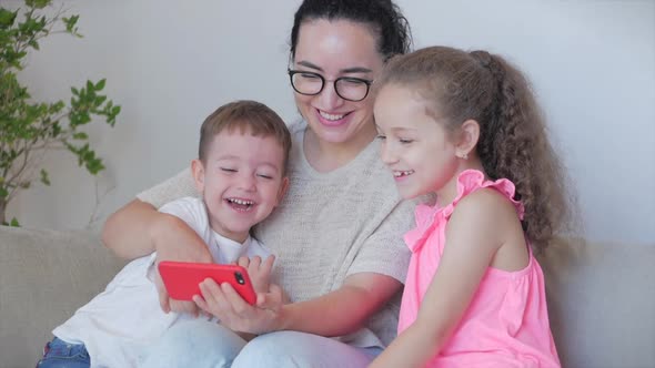 Happy Family,mom and Cute Little Kids,mother Playing with Children at Home Relaxing Use a Smartphone