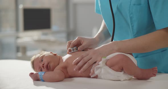 Pediatric Doctor Exams Newborn Baby with Stethoscope in Hospital