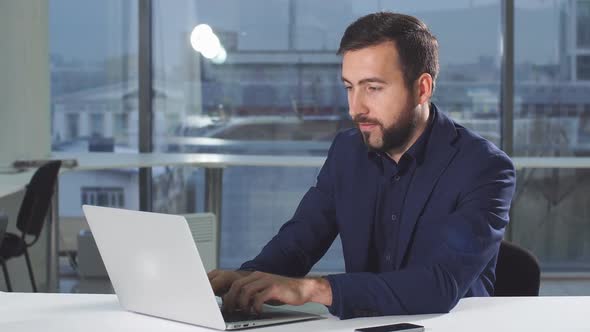 Handsome Man Working Using Laptop Looking in Monitor Screen