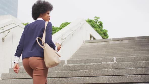 African american businesswoman holding takeaway coffee and walking