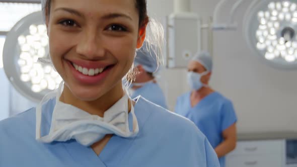 Portrait of a mixed race female surgeon working in a hospital operating theatre, wearing face mask f