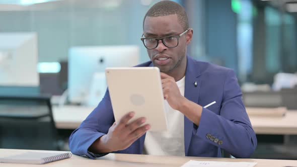 African Businessman Making Video Call on Tablet in Office