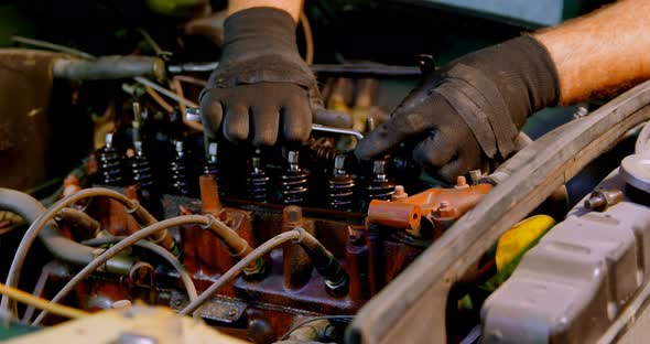 Male mechanic servicing a car in garage 4k