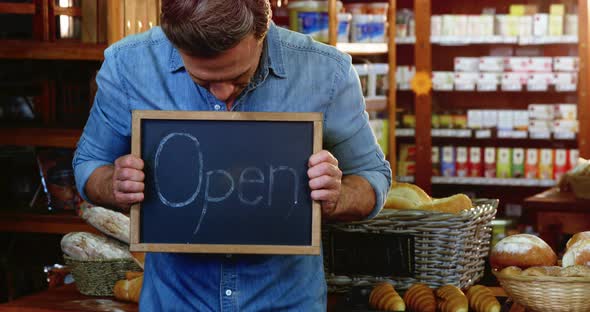 Owner holding open signboard slate