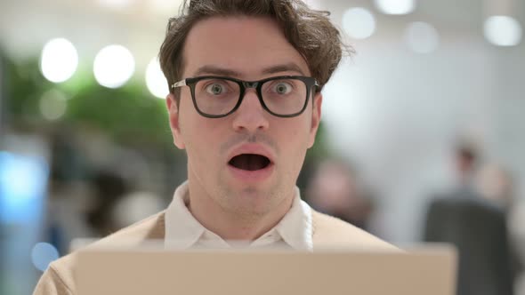 Close Up of Shocked Young Male Designer with Laptop