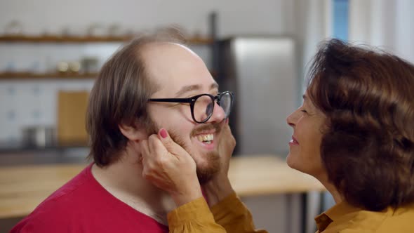 Senior Pleasant Woman Touching Her Son Cheek While Showing Her Affection