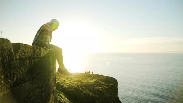 Young man looking at sunset view, ocean and sunlight in the background