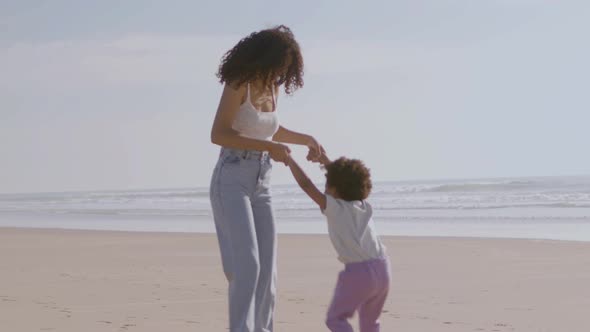 Happy Mother and Two Children Having Fun at Seashore