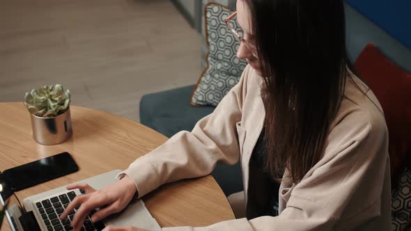 Young Caucasian Woman Using Laptop Notebook Looking at Screen Typing Message, Woman Chatting on