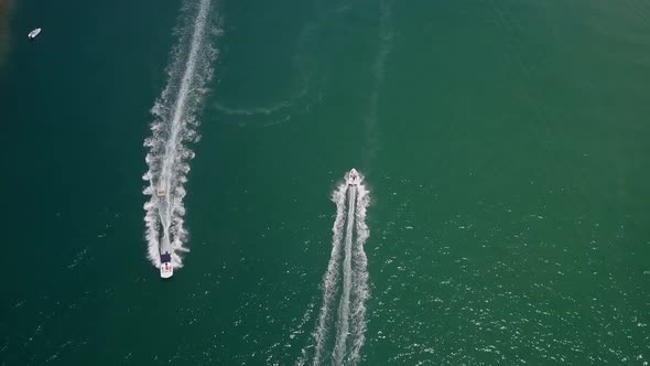 Recreation boaters enjoy vivid green lagoon on warm sunny day, aerial