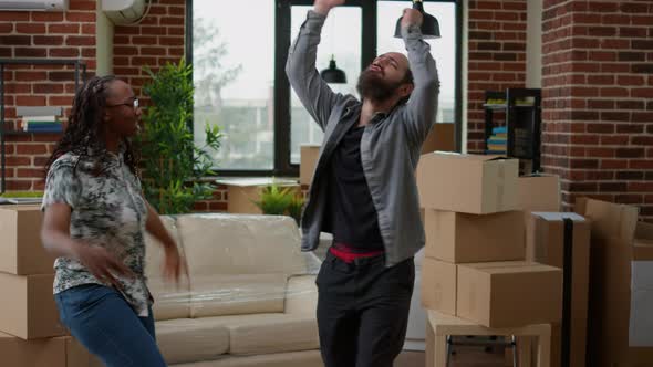 Diverse Couple Dancing in New Home Celebrating Moving in Together