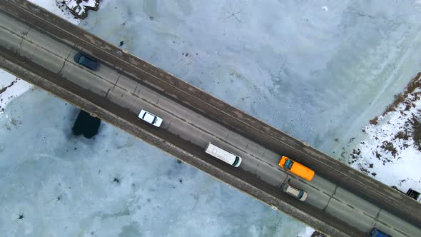 Topdown View of Cars Passing Small Bridge Over Frozen Small River in European City