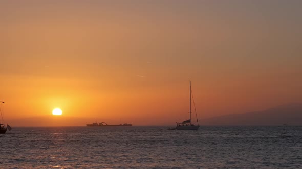 Sunset in Mykonos, Greece, with Cruise Ships and Yachts in the Harbor