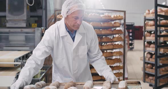 Old Man Baker in White Uniform Load the Shelf of