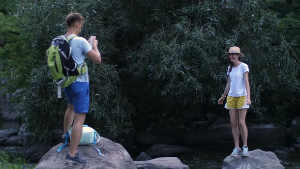 Male Hiker Taking Photo of Woman on Cellphone